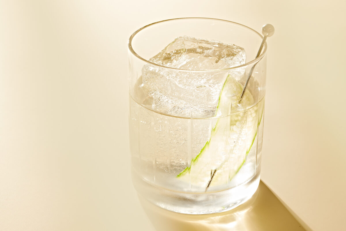 a white negroni cocktail with light shining through it