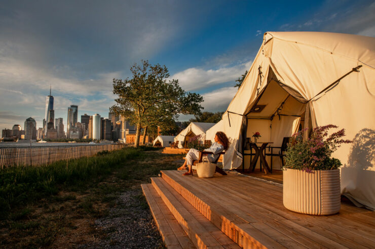 woman camping on governors island overlooking the nyc skyline