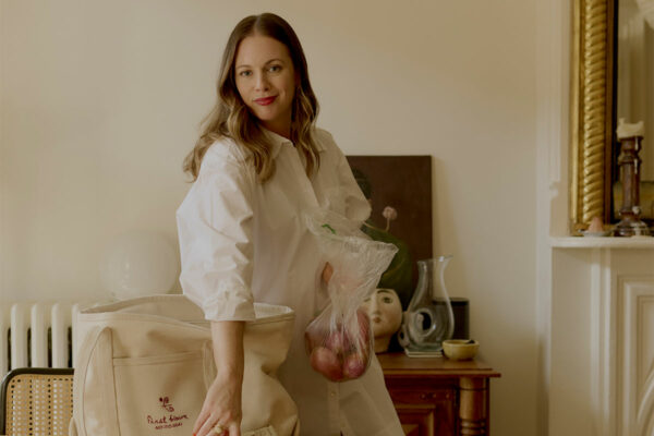 alison roman posing with groceries at her kitchen table